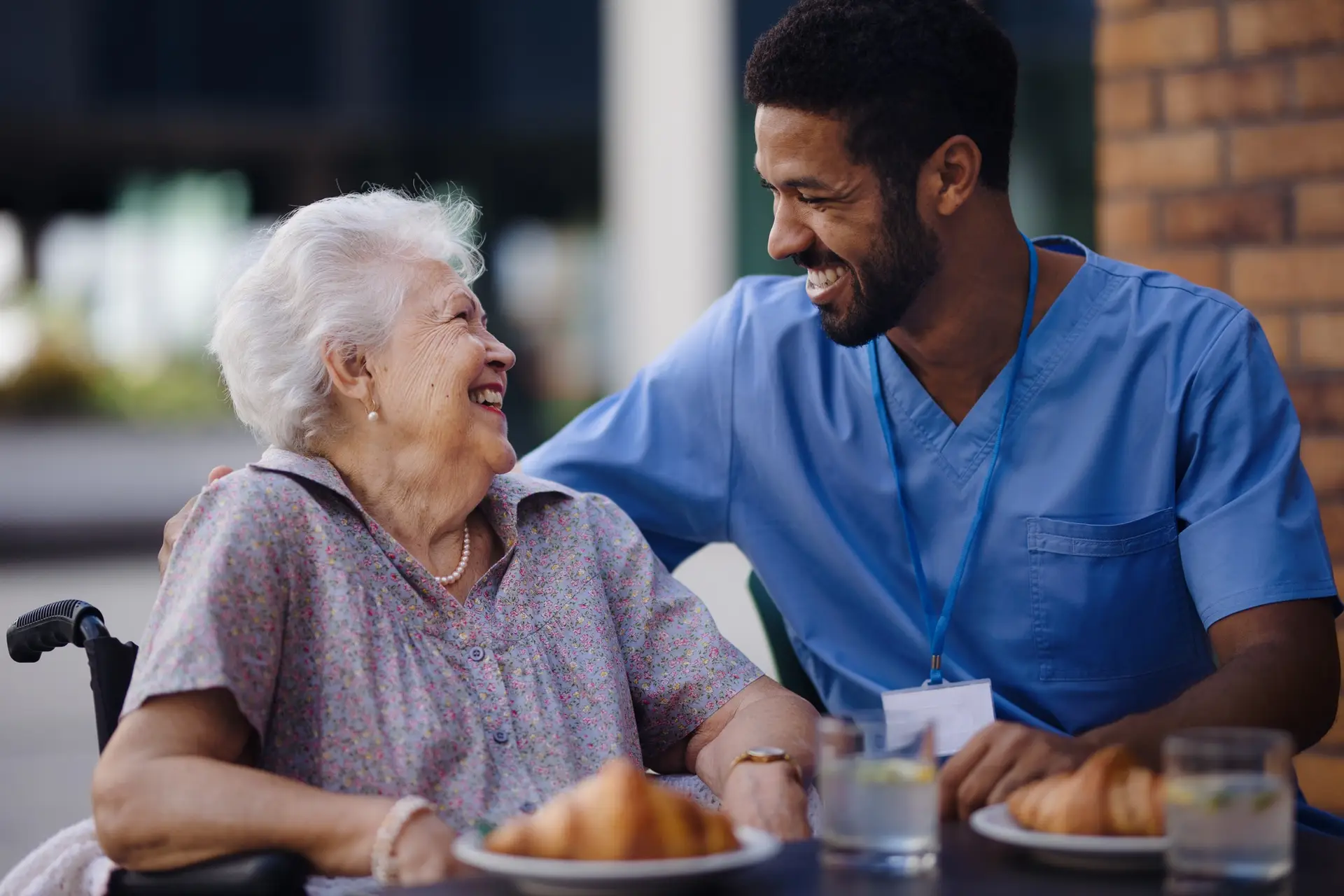 Caregiver having breakfast with his client at cafe.